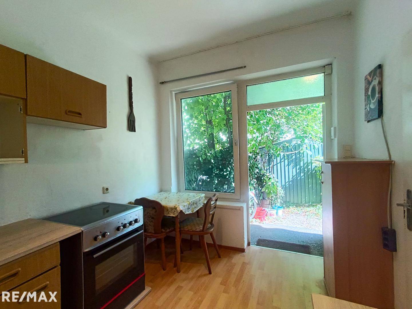 Helle, funktionale Küche mit Esstisch, Herd und direktem Zugang zum Garten.