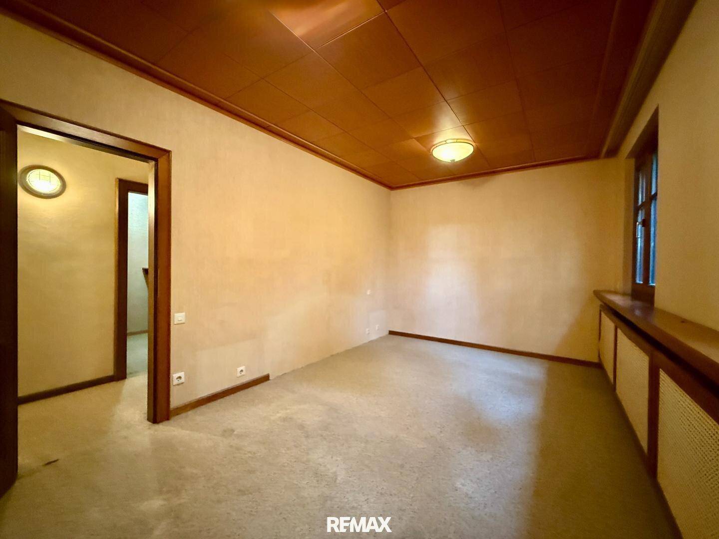 Helles Schlafzimmer mit Teppichboden, Holzdecke und Fenster mit Blick nach draußen.
