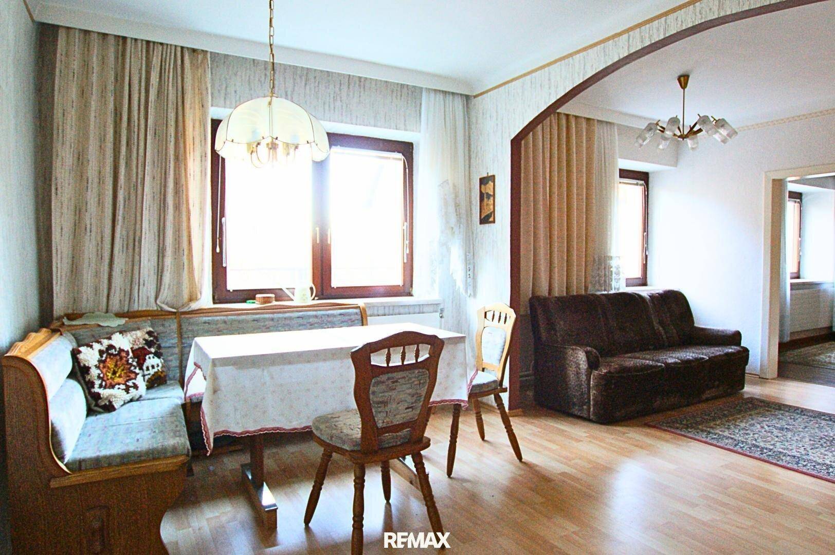 Heller Wohn- und Essbereich mit Holzboden, gemütlicher Sitzecke und Sofa.