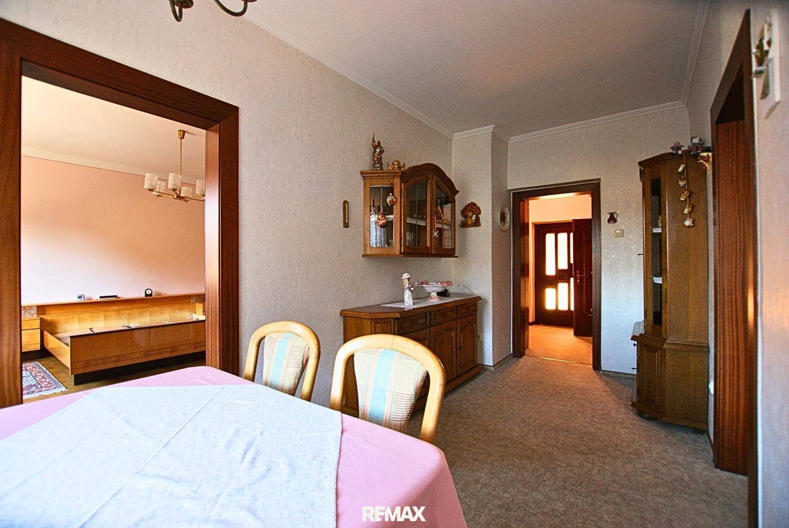 Esszimmer mit Esstisch, Holzmöbeln und Zugang zu angrenzenden Räumen.