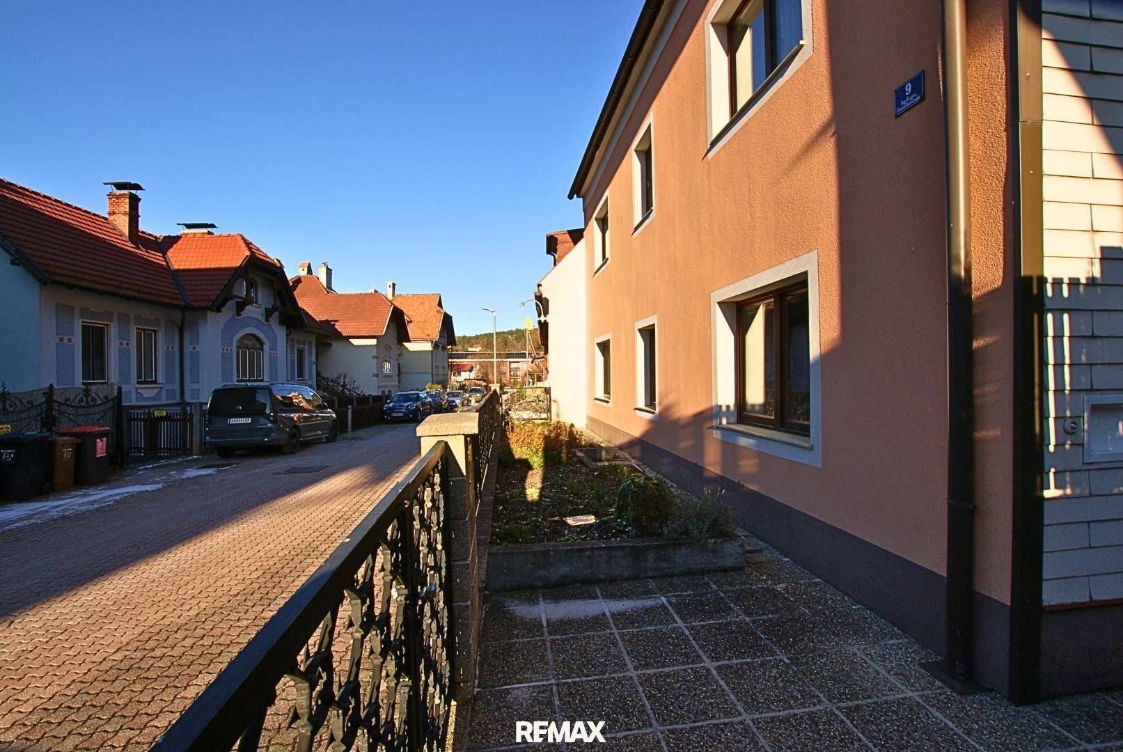 Seitenansicht des Wohnhauses mit Zugang zum Grundstück und Blick auf die ruhige Wohnstraße.