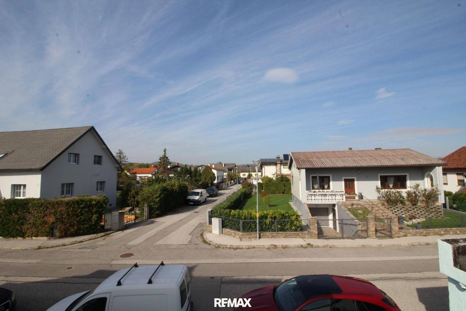 Weitläufige Straßenansicht einer ruhigen Wohngegend mit Einfamilienhäusern.