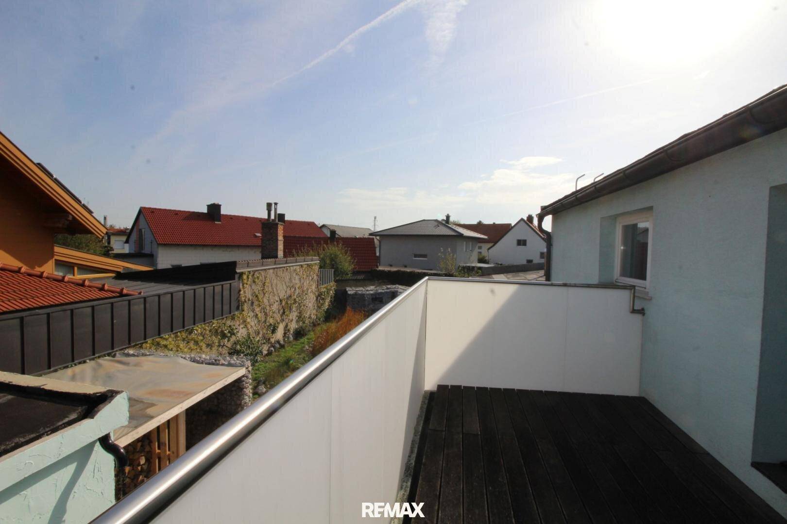 Moderner Balkon mit Holzboden und weitem Blick über die umliegende Nachbarschaft.