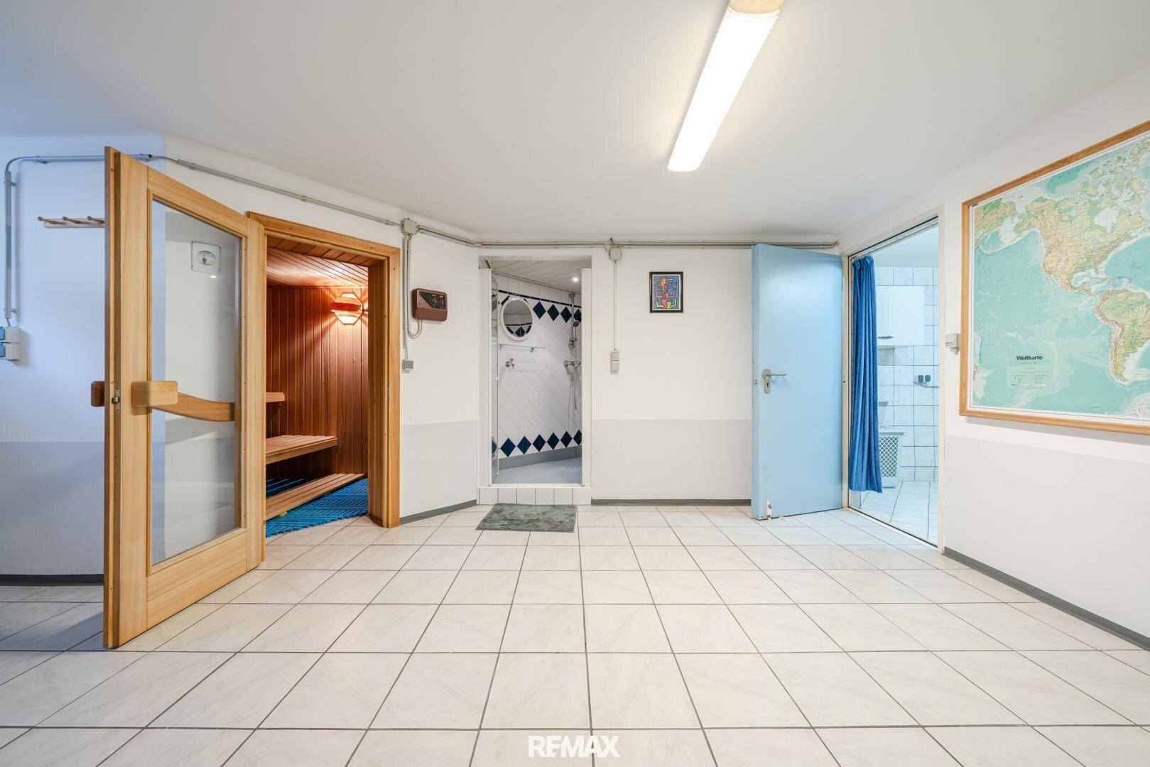 Kellerbereich mit Fliesenboden, einer Sauna und einem Duschbereich, ideal für Wellness.