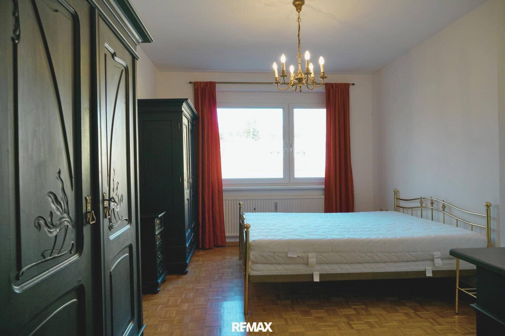 Schlafzimmer mit traditionellen Holzschränken, Metallbett und Parkettboden, klassisch eingerichtet.