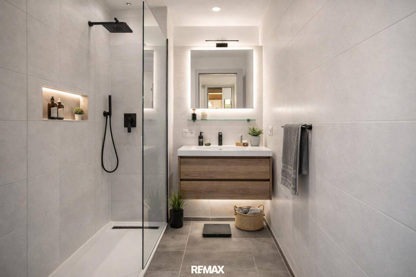 Modernes Badezimmer mit begehbarer Dusche, elegantem Waschtisch und beleuchtetem Spiegel.