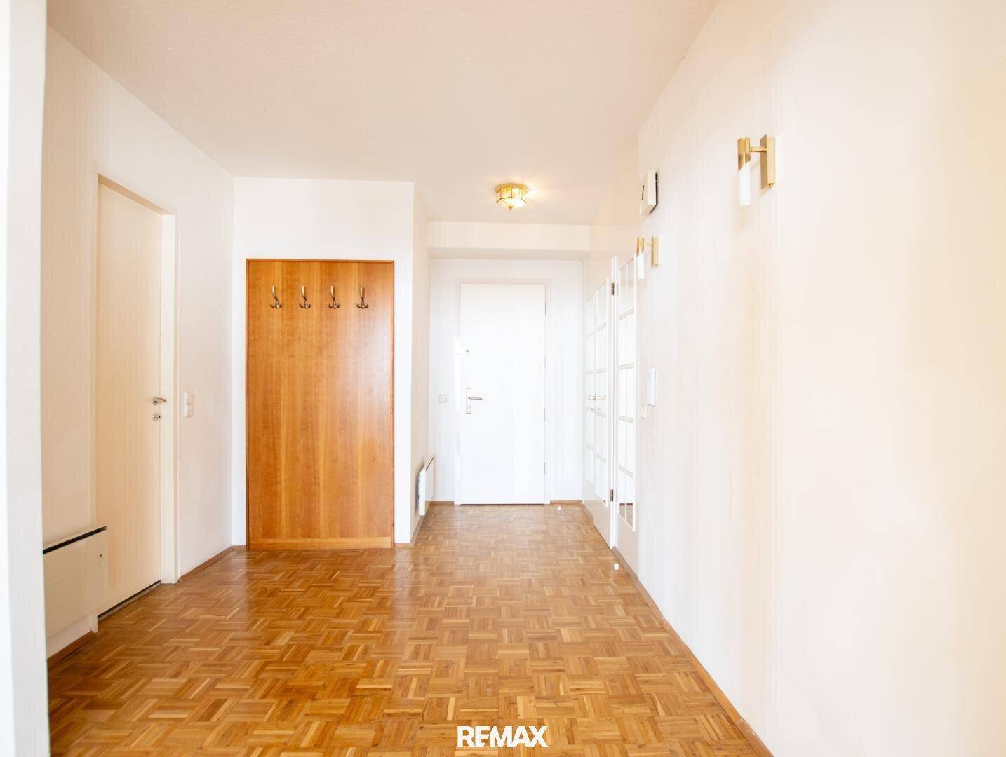 Heller Flur mit Parkettboden, Garderobe und Zugang zu verschiedenen Räumen der Wohnung.