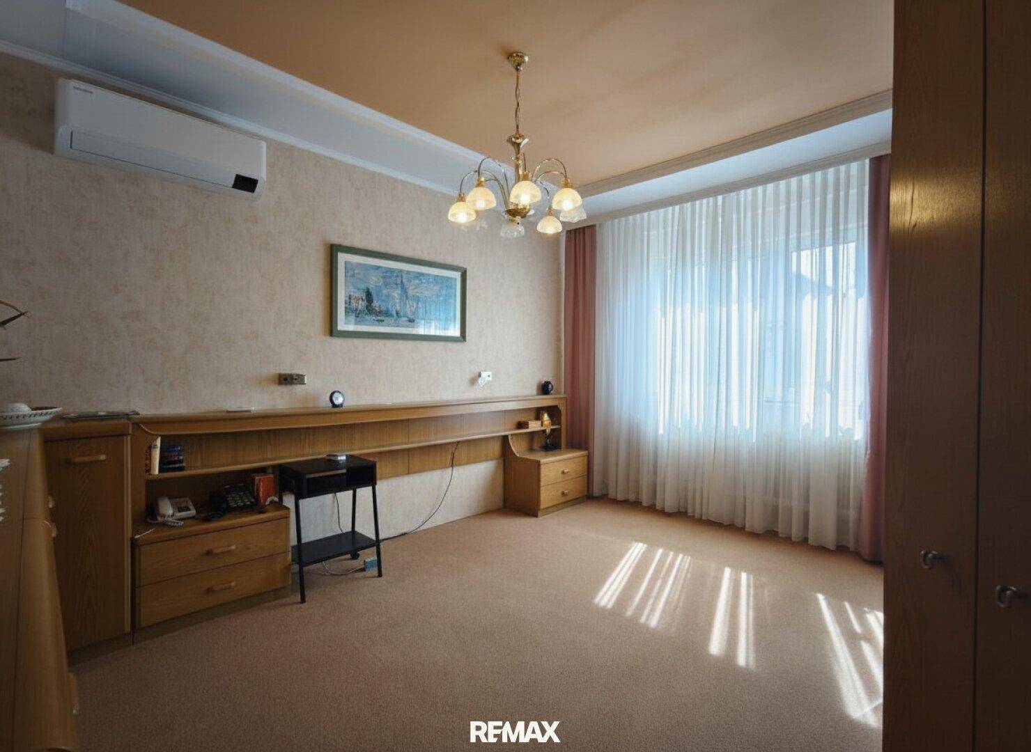 Geräumiges Schlafzimmer mit Teppichboden, Klimaanlage und großem Fenster für viel Tageslicht.