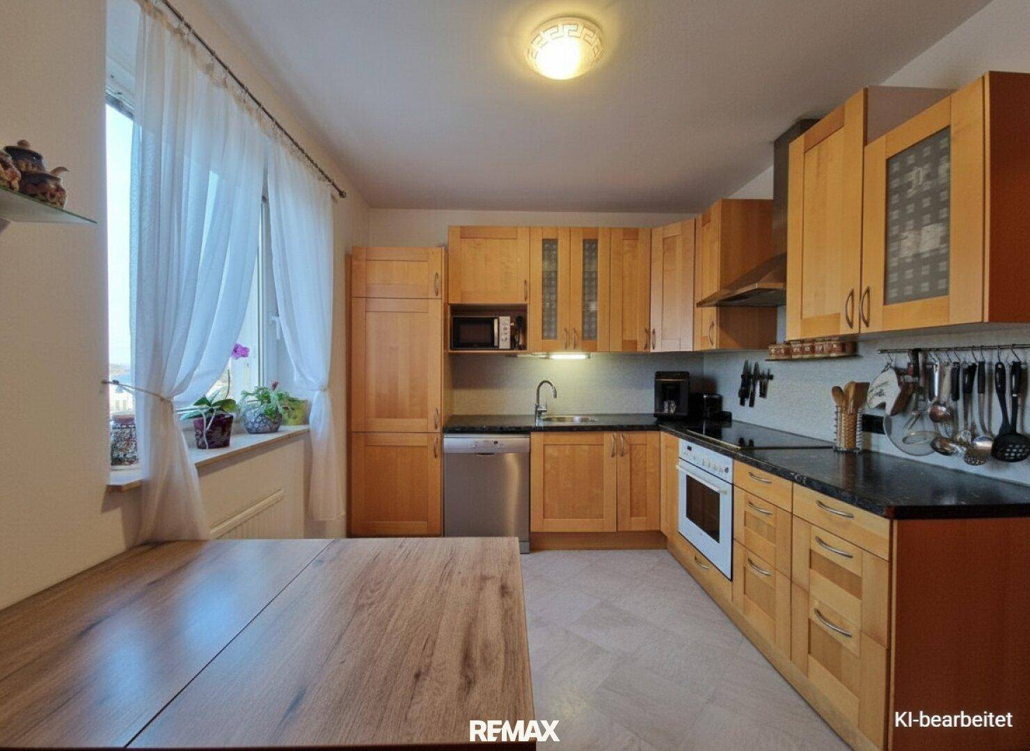 Helle Küche mit Holzschränken, Essbereich und Fenster nach Modernisierung.