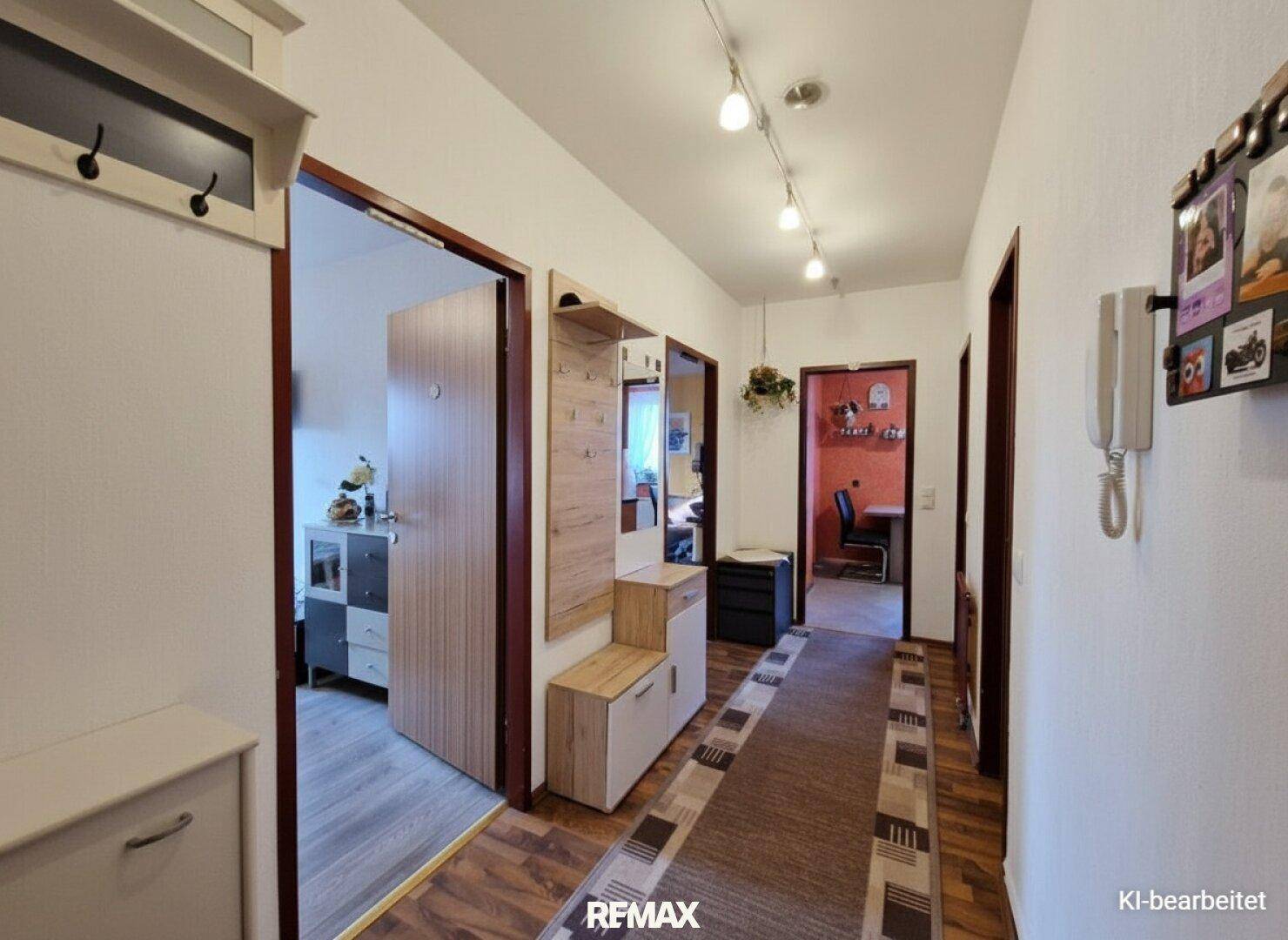 Modernisierter Flur mit hellen Wänden, Garderobe und Laminatboden.