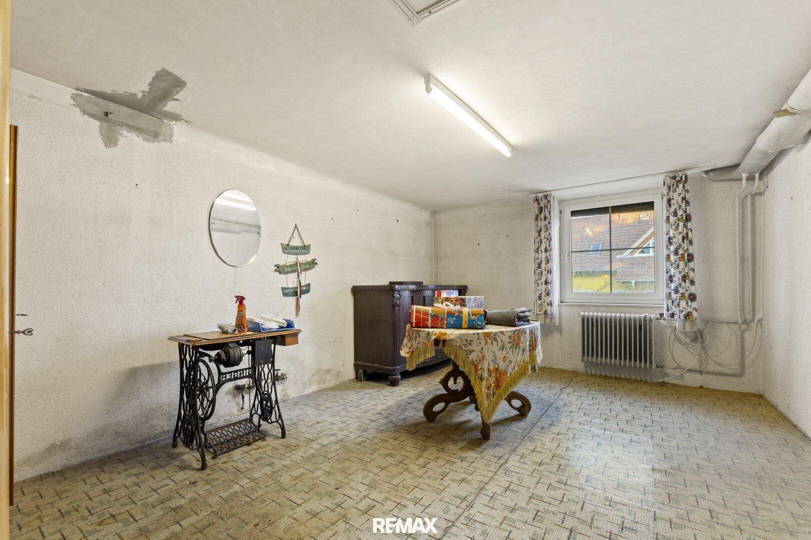 Heller Kellerraum mit Fenster und einfacher Einrichtung, nutzbar als Hobbyraum.