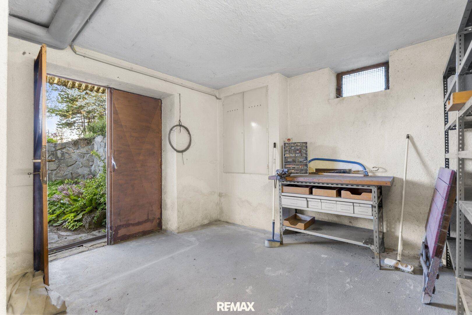 Werkstatt im Keller mit direktem Zugang zum Garten und Regalsystemen.