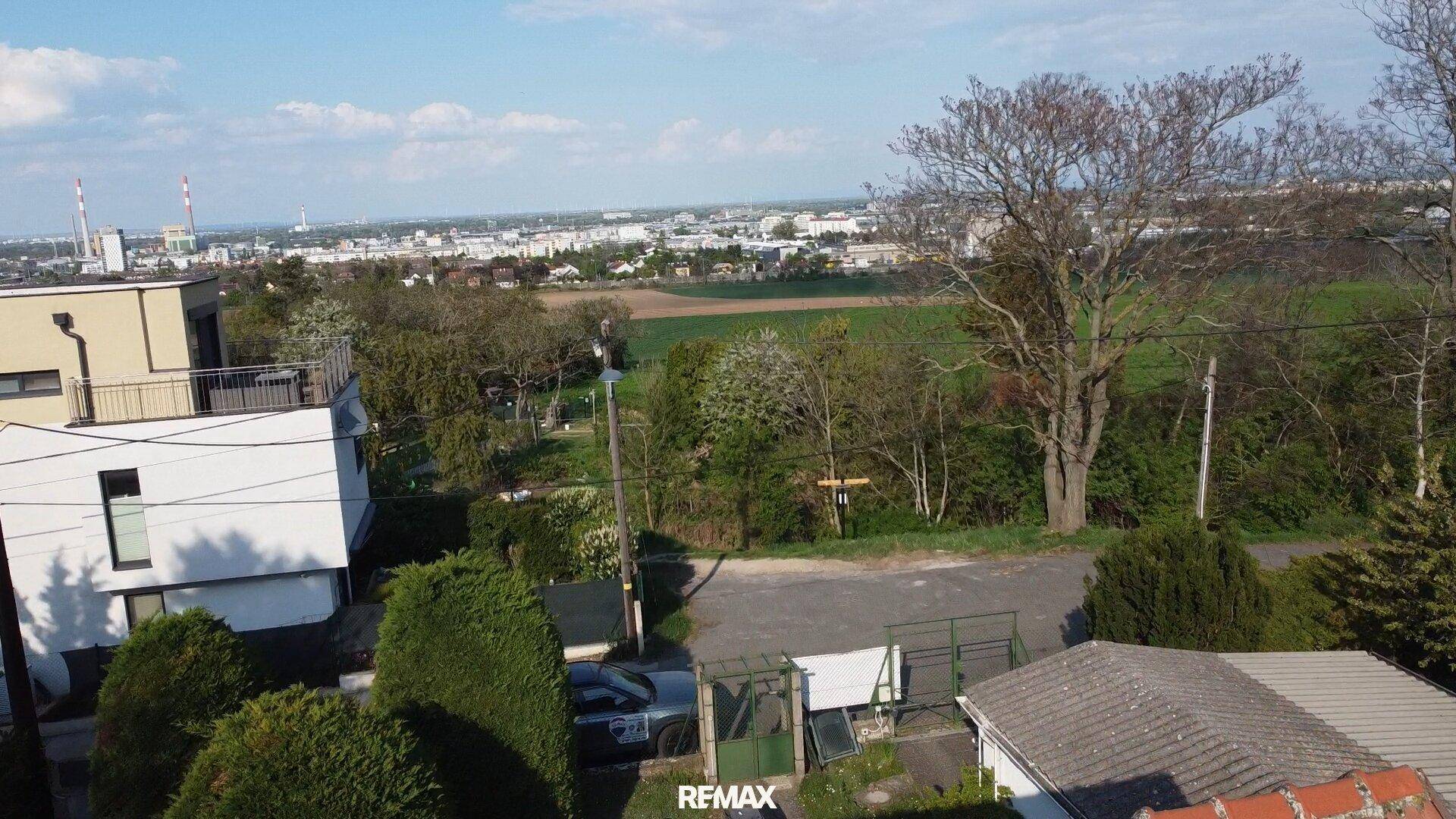 Weitblick über die ländliche Umgebung mit Feldern und einer Stadt am Horizont.