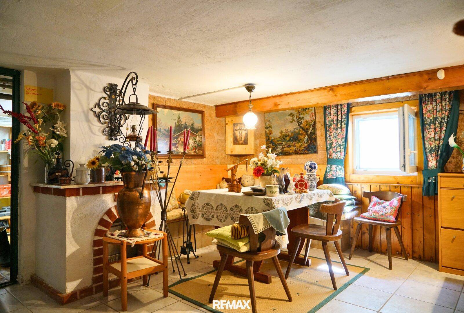 Rustikaler Essbereich mit Holztisch, Stühlen und traditioneller Dekoration.