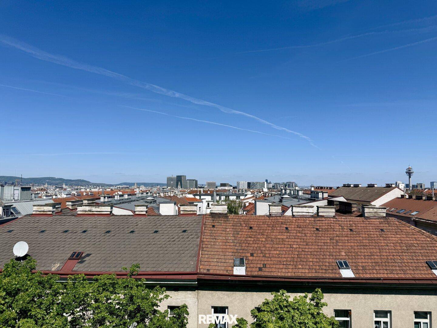 Weitläufiger Stadtblick über die Dächer mit klarer Sicht auf die Skyline.