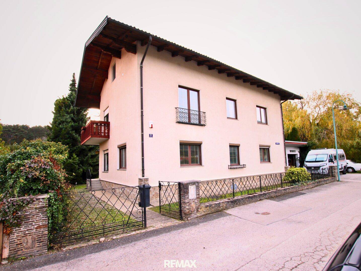 Ansicht des Einfamilienhauses mit Balkon und Vorgarten in einer ruhigen Wohngegend.