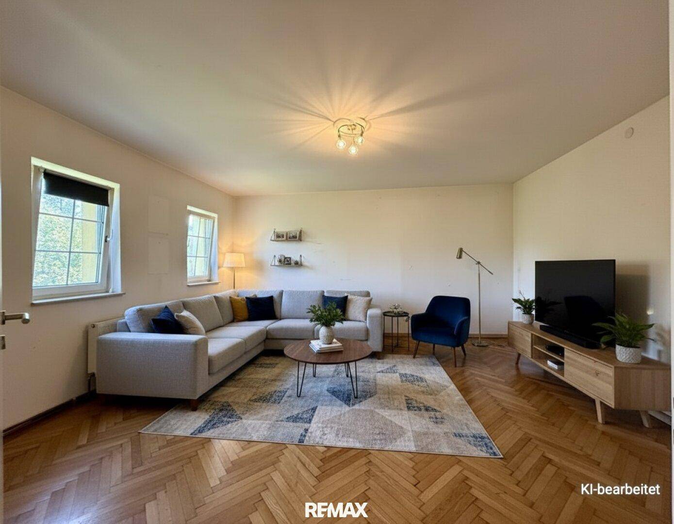 Helles Wohnzimmer mit großem Ecksofa, Teppich und Fischgrätparkett, sehr einladend.