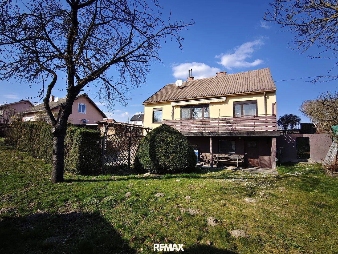 Großzügiger Gartenbereich mit Rasenfläche und altem Baumbestand vor dem Einfamilienhaus.
