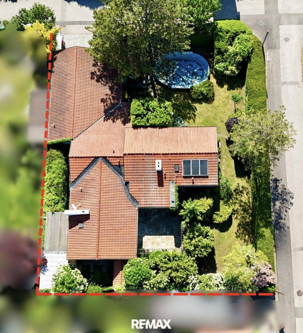 Übersichtliche Luftaufnahme des Grundstücks mit roter Umrandung und Gartenbereich.