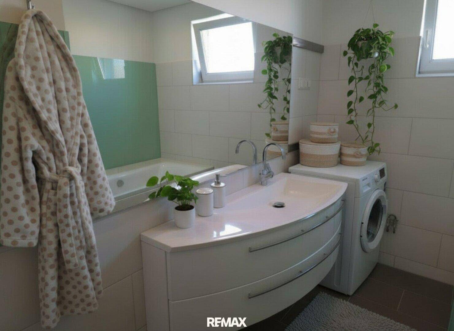 Helles Badezimmer mit Badewanne, Waschbeckenunterschrank und integrierter Waschmaschine.