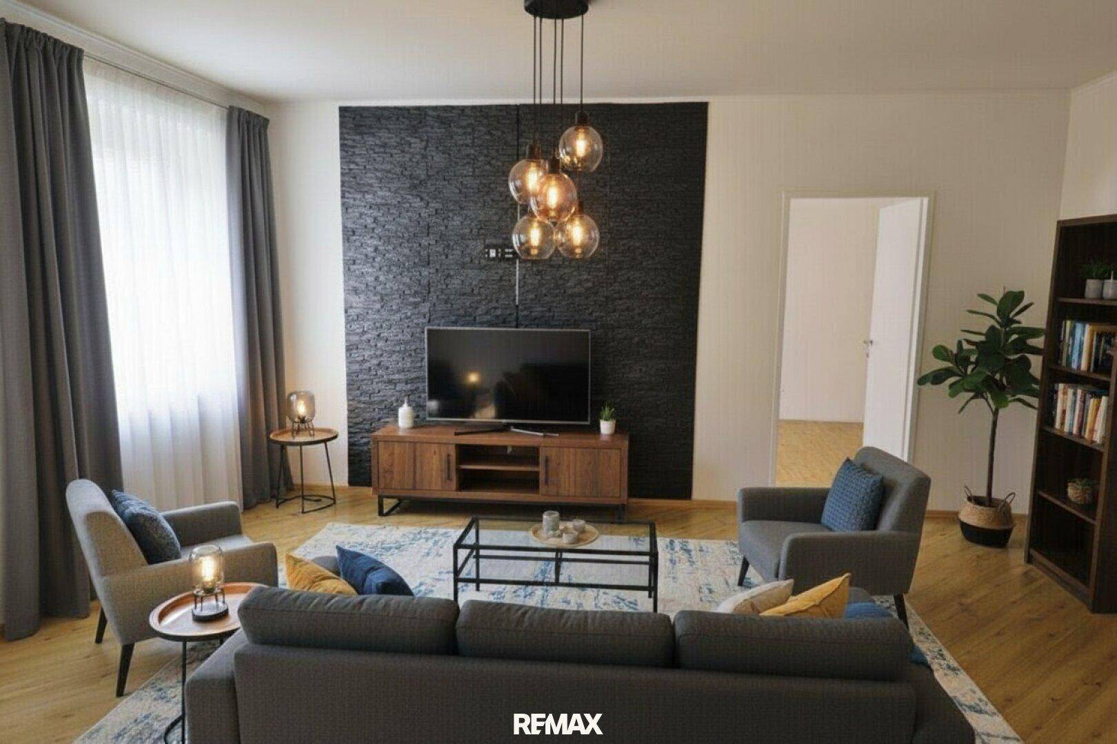 Gemütliches Wohnzimmer mit dunkler Akzentwand, modernem Sofa und stilvoller Beleuchtung.