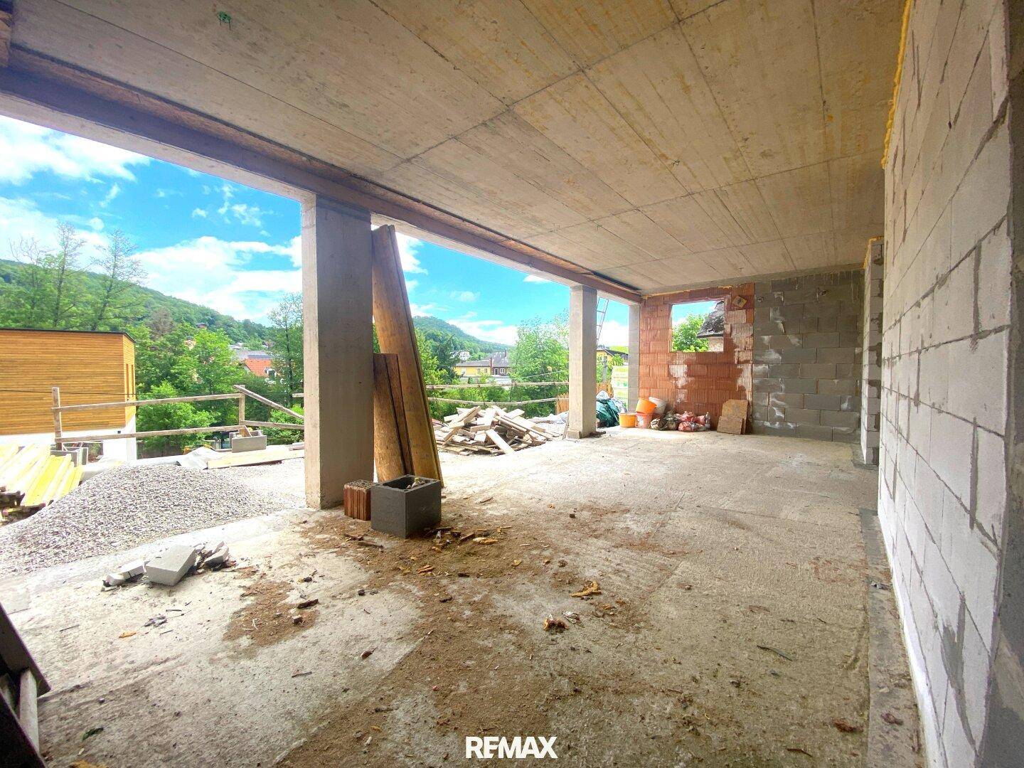 Geräumiger Rohbau mit weitem Ausblick auf die umliegende Landschaft und Hügel.