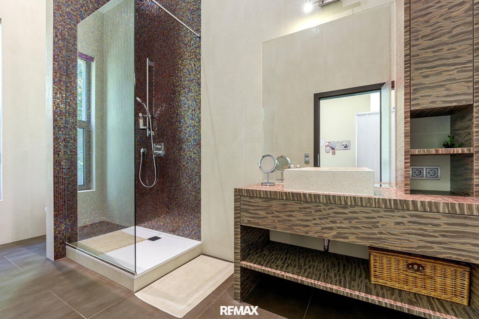 Modernes Badezimmer mit begehbarer Dusche, Mosaikfliesen und elegantem Waschtisch.