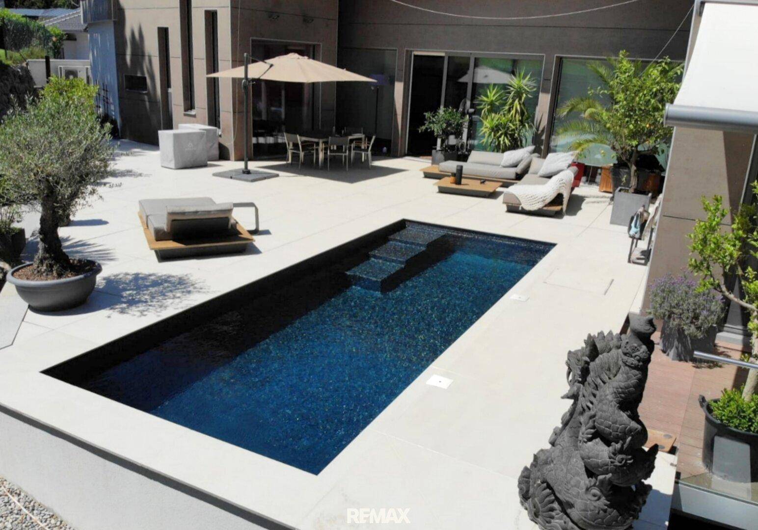 Detailansicht der großzügigen Terrasse mit Swimmingpool und stilvollen Lounge-Möbeln.