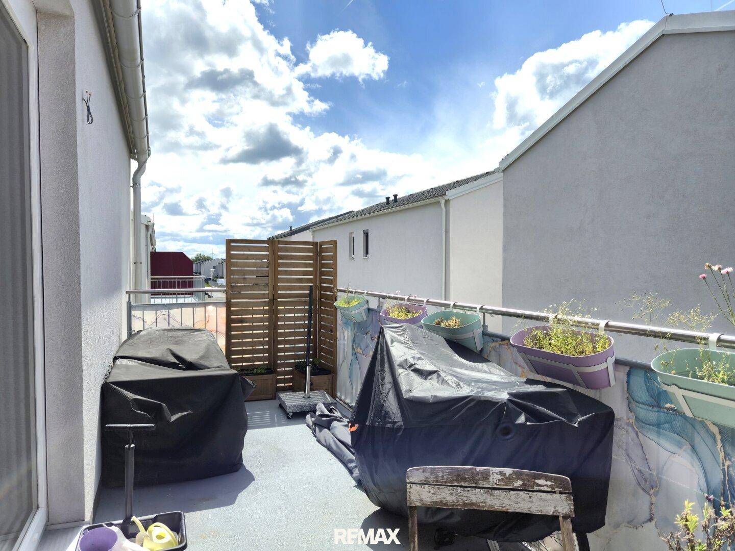 Geräumiger Balkon mit Sichtschutz und Pflanzen, ideal für entspannte Stunden im Freien.