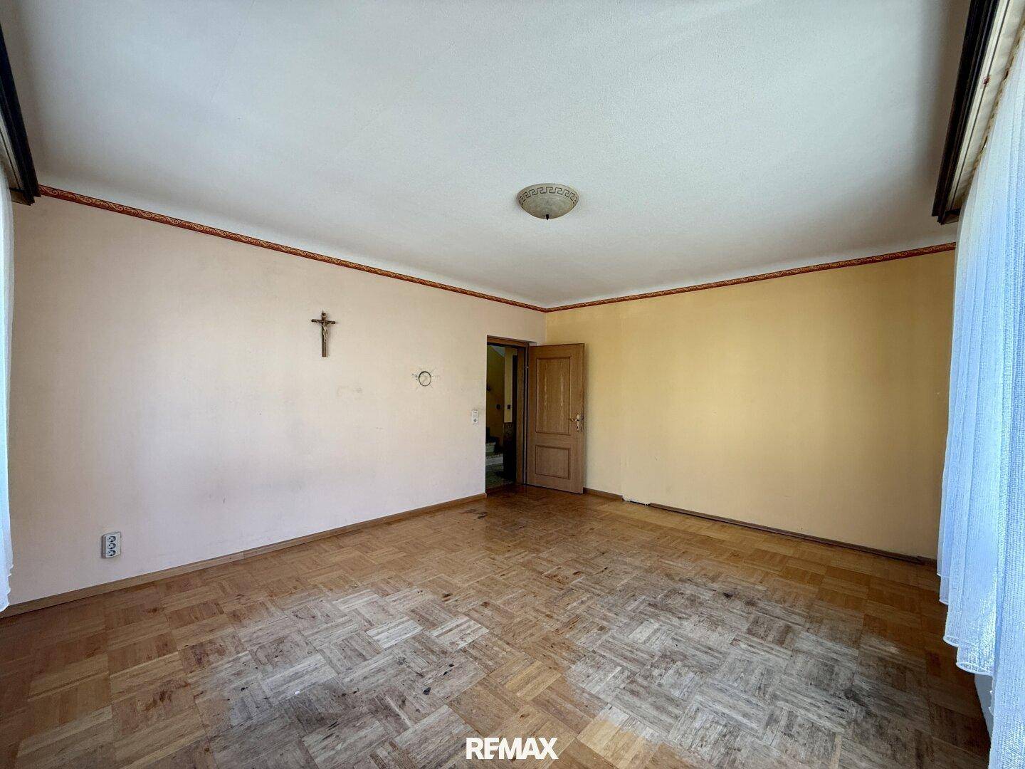 Geräumiges Zimmer mit Parkettboden und heller Wandfarbe, bereit zur individuellen Gestaltung.