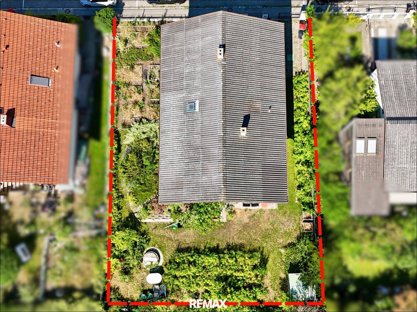 Luftaufnahme des Hauses mit großem Grundstück und Gartenbereich, umgeben von Grün.