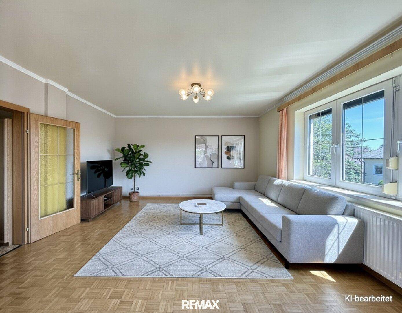 Modern eingerichtetes Wohnzimmer mit Sofa, Couchtisch und Parkettboden.