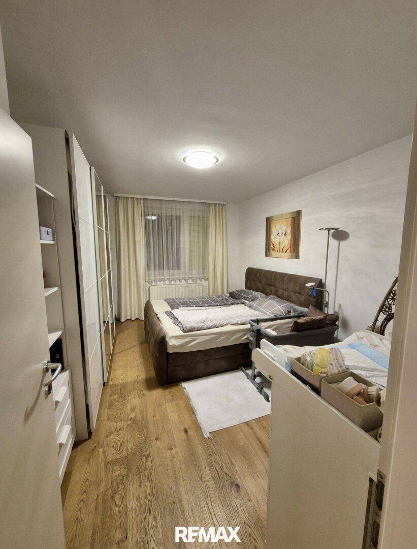 Gemütliches Schlafzimmer mit Doppelbett, großem Kleiderschrank und Holzboden.
