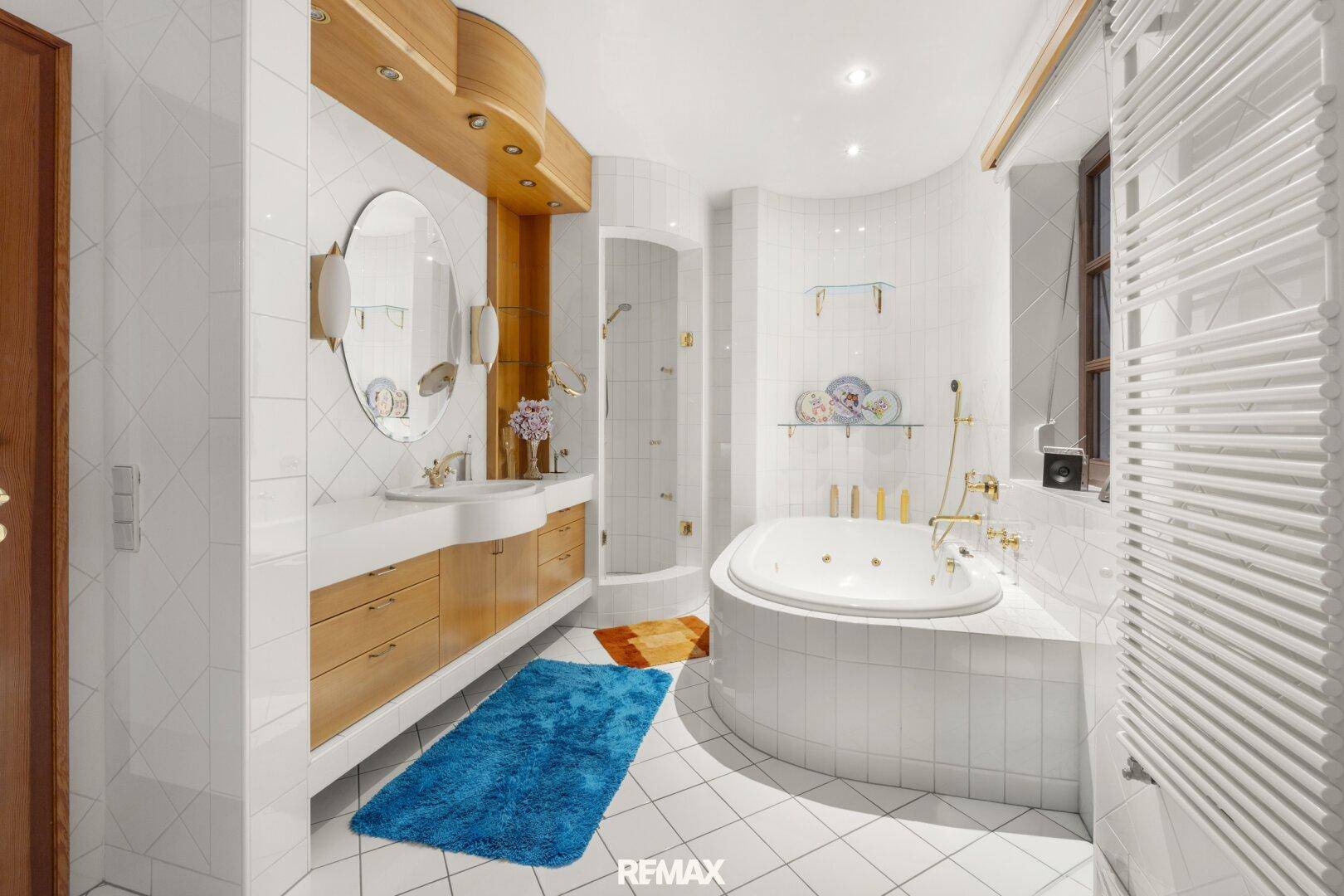 Helles Badezimmer mit Whirlpool-Badewanne, Dusche und Doppelwaschbecken.