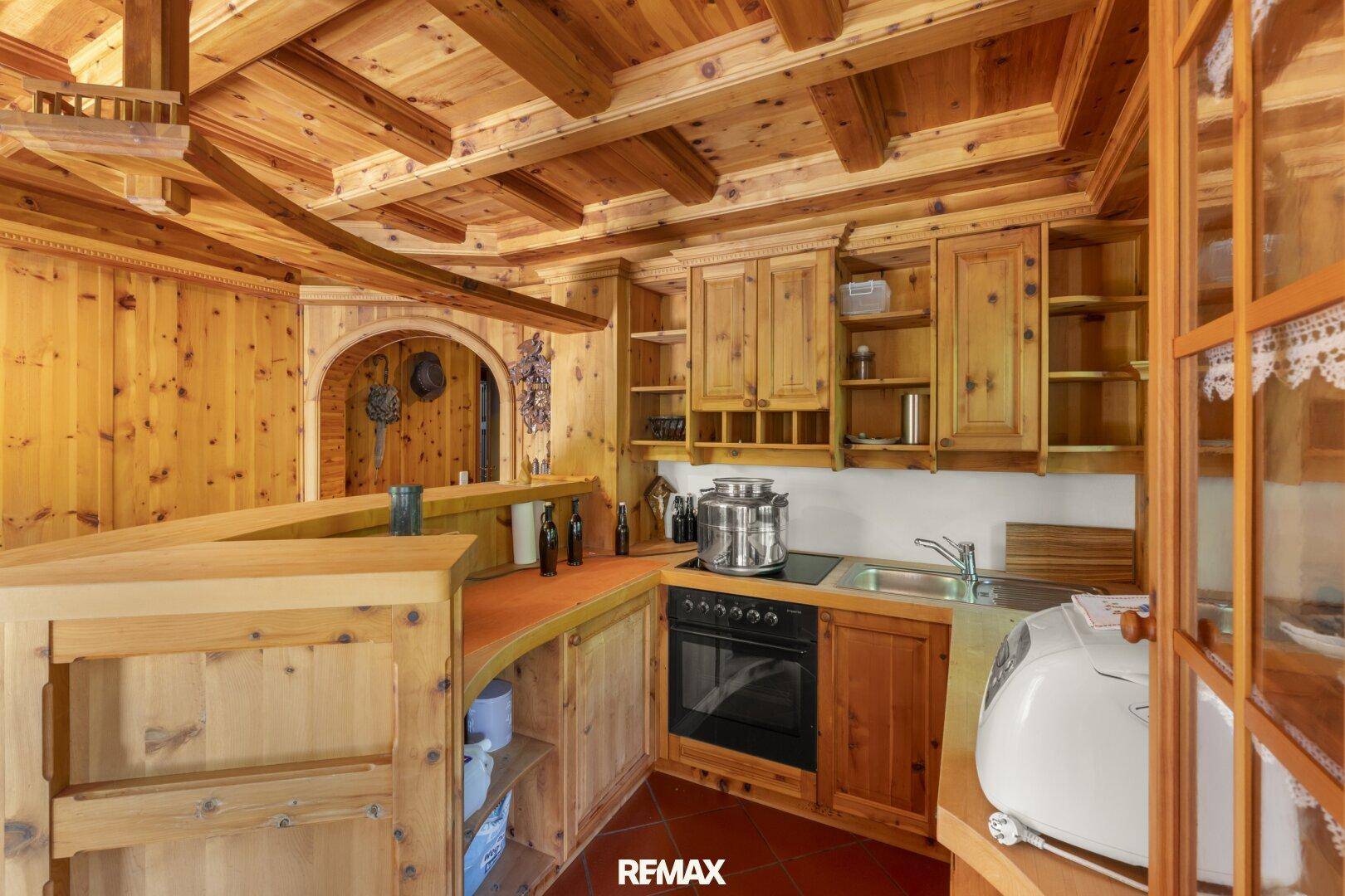 Gemütliche Holzküche mit Einbaugeräten, Arbeitsplatte und rustikalem Charme.