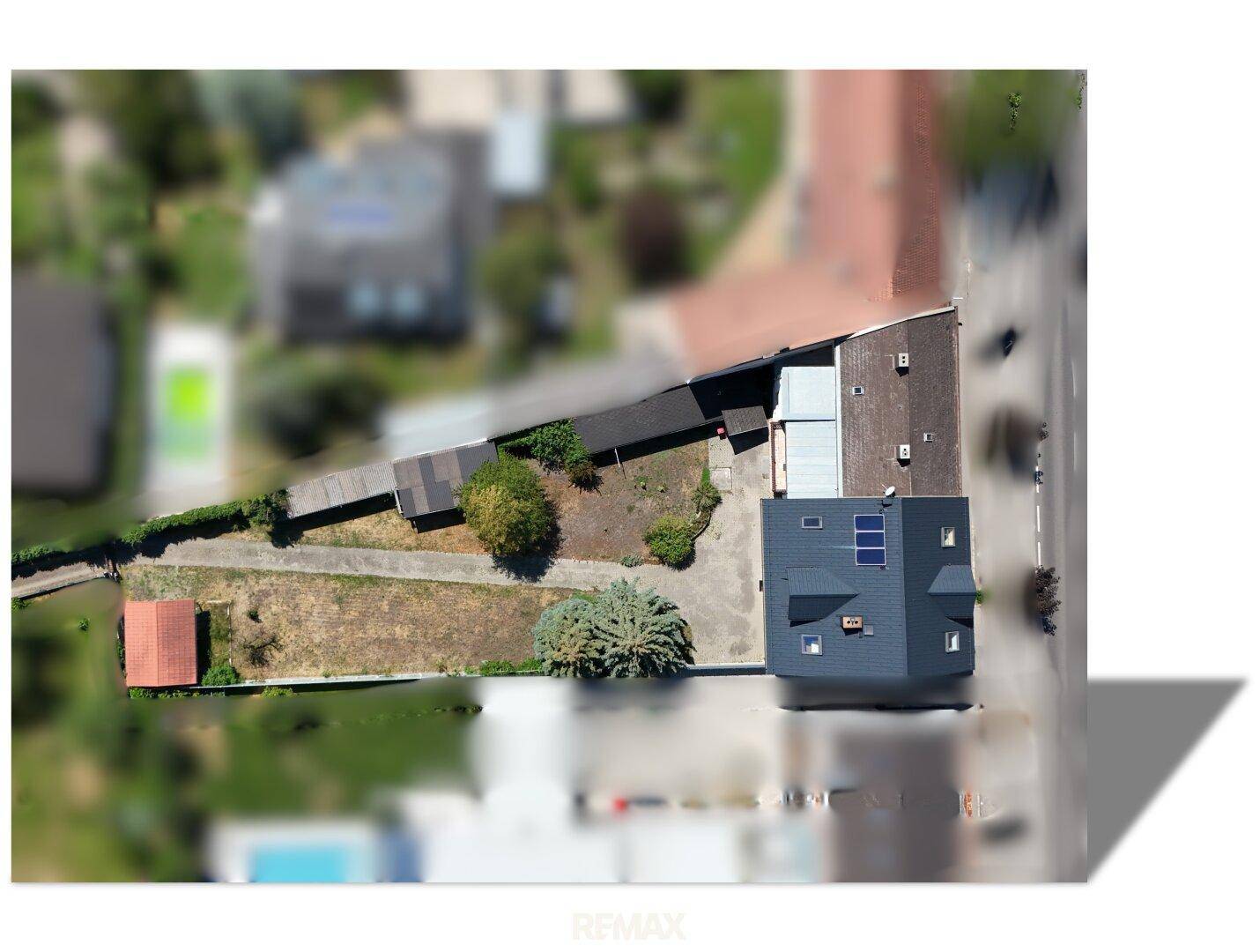 Vogelperspektive des Grundstücks mit Gebäude, Gartenbereich und angrenzenden Nachbargrundstücken.