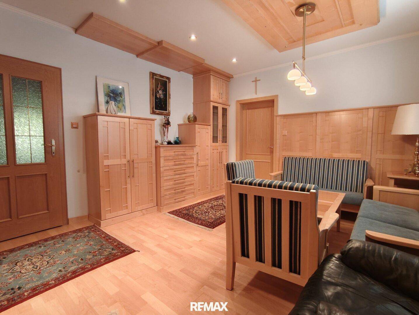 Helles Wohnzimmer mit Holzmöbeln, Parkettboden und traditioneller Einrichtung.