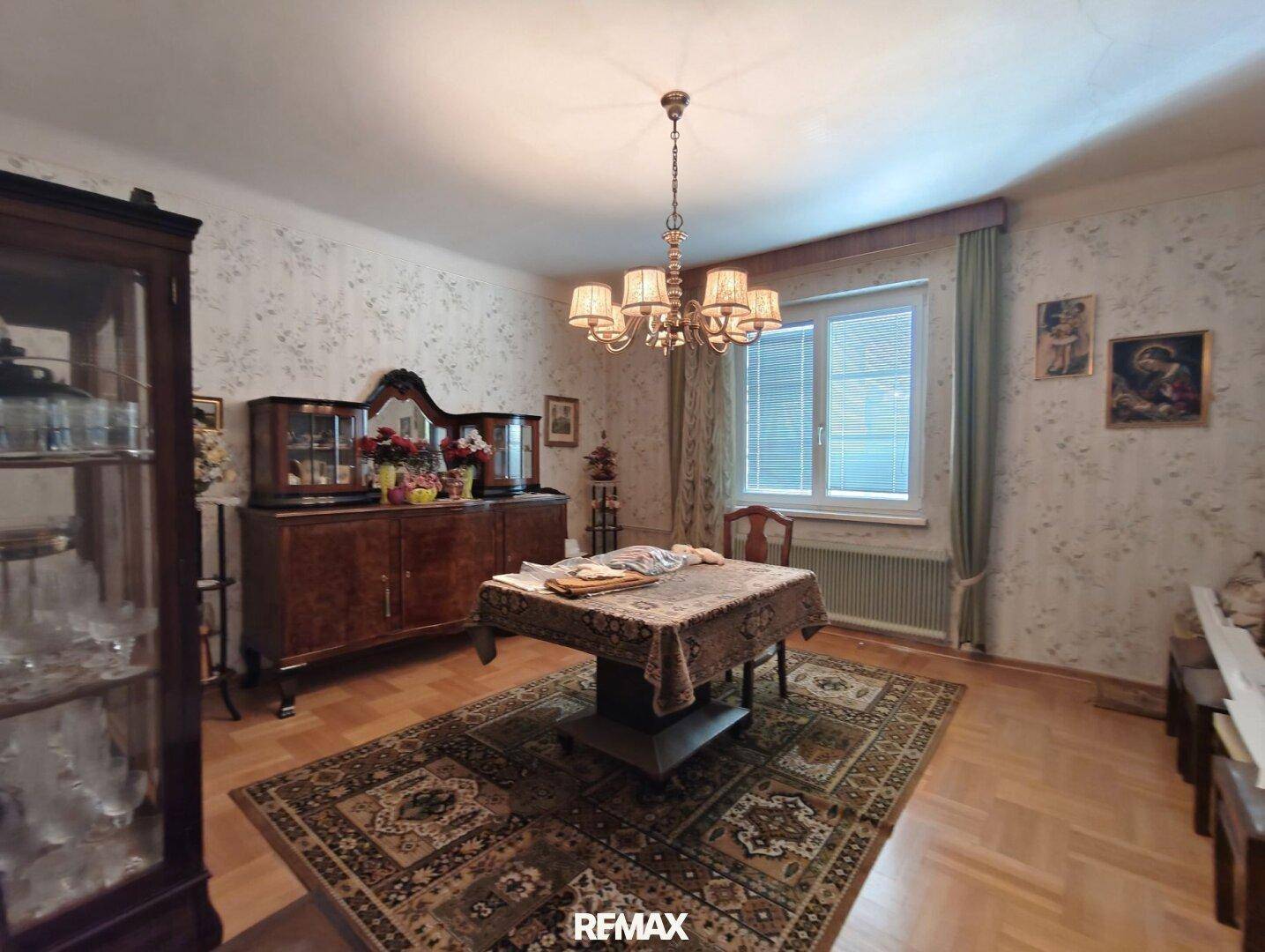 Esszimmer im klassischen Stil mit Holzboden, großem Teppich und traditionellen Möbeln.