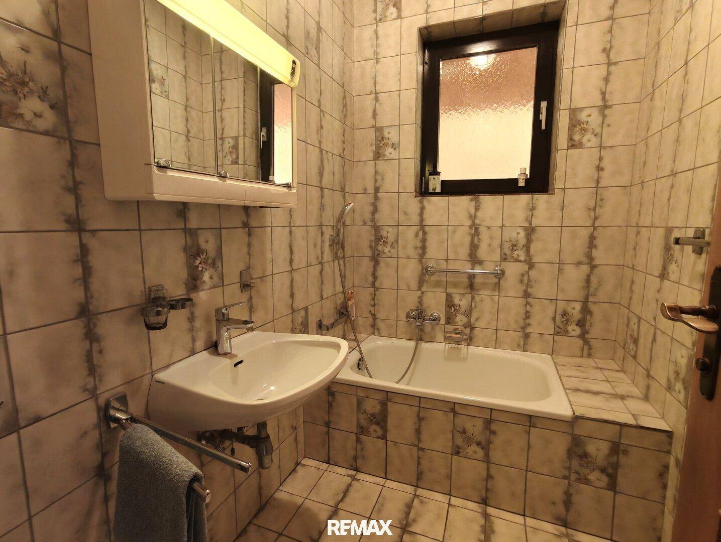 Kleines Badezimmer mit Badewanne, Waschbecken und Fliesen im traditionellen Stil.