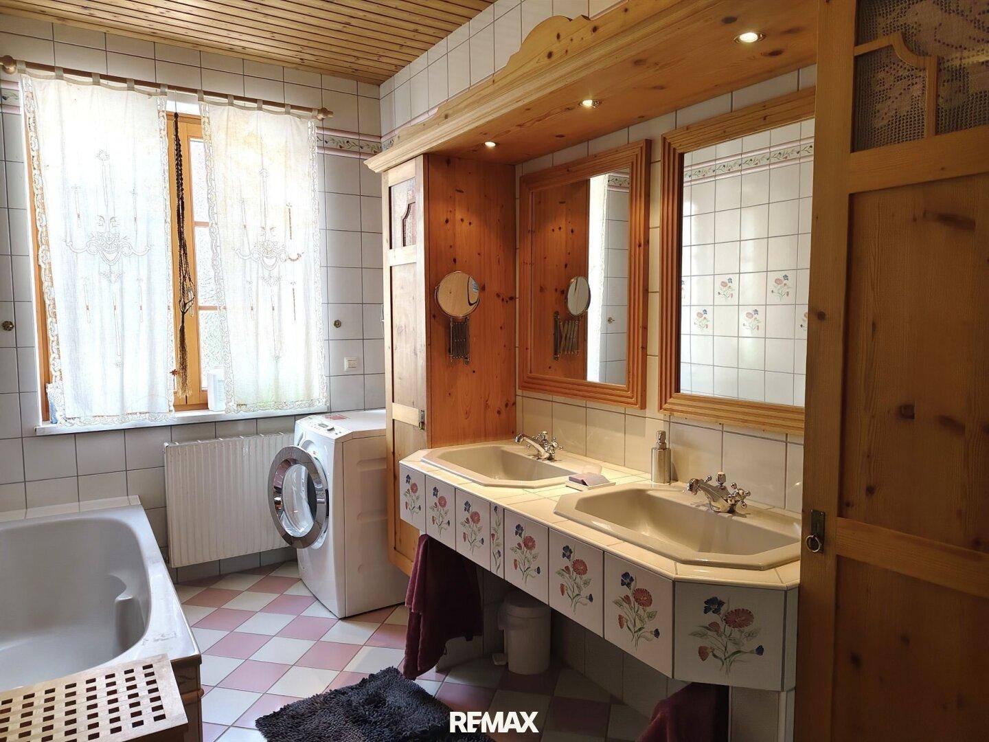 Badezimmer im traditionellen Stil mit Doppelwaschbecken, Badewanne und Waschmaschine.