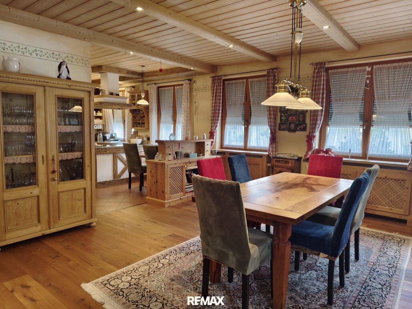 Gemütlicher Wohn-Essbereich im Landhausstil mit Holzbalkendecke und traditionellen Möbeln.