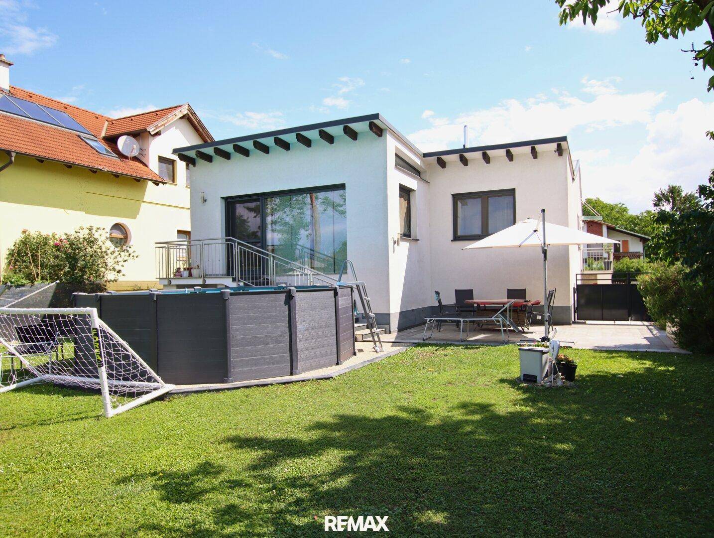 Modernes Haus mit großem Garten, Aufstellpool und sonniger Terrasse.