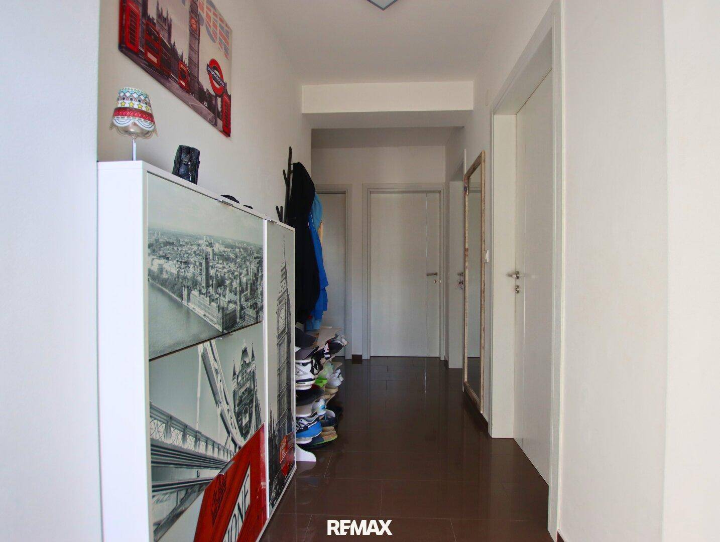 Eingangsbereich mit Schuhschrank, Garderobe und Spiegel, führt zu weiteren Räumen.