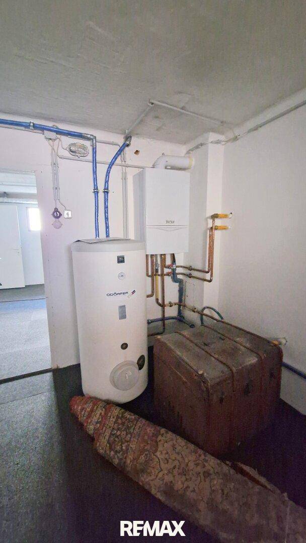 Heizungsraum im Keller mit Warmwasserspeicher und Heizungsanlage.