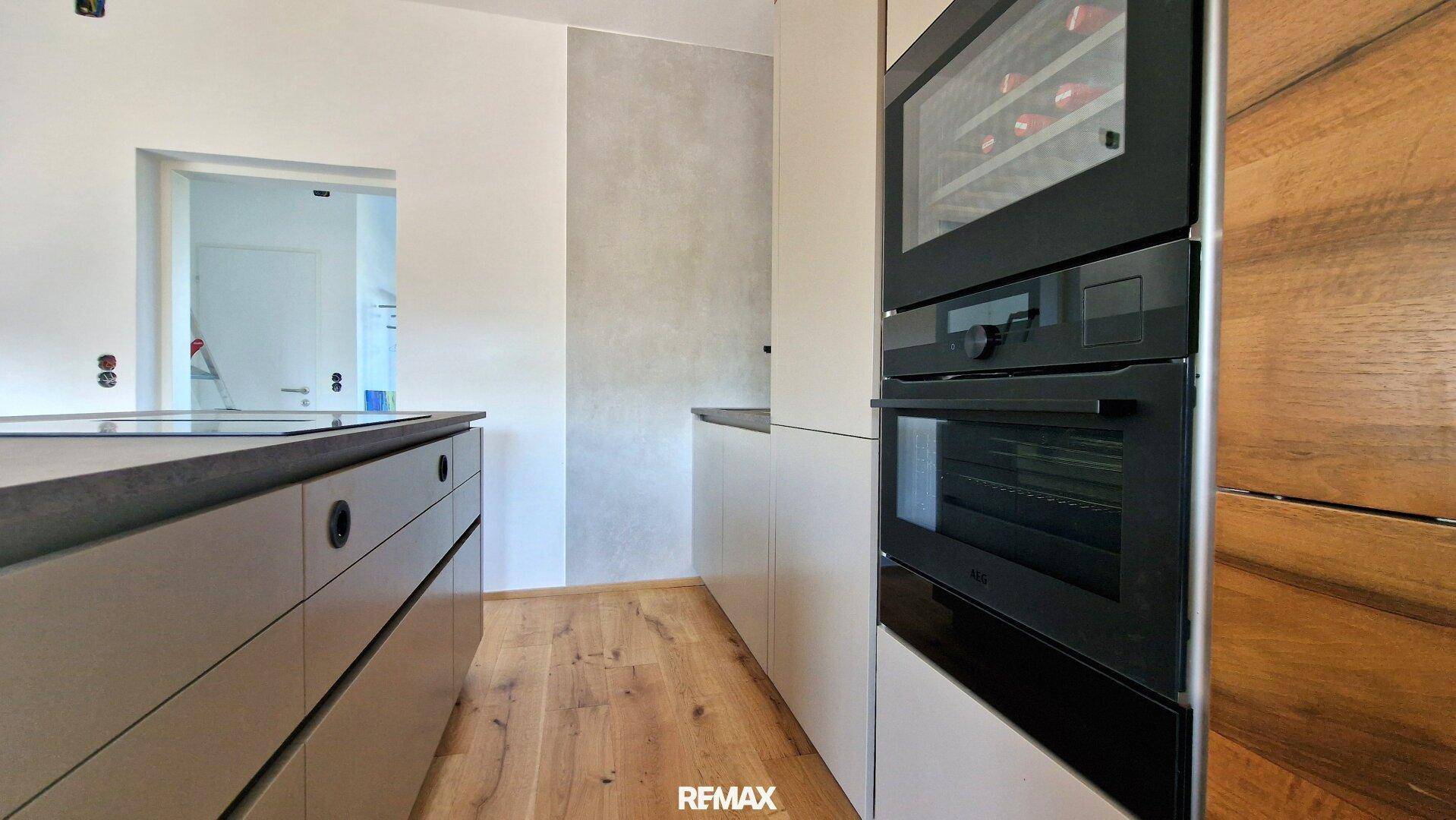 Detailansicht der modernen Küche mit integriertem Backofen und Weinkühlschrank.