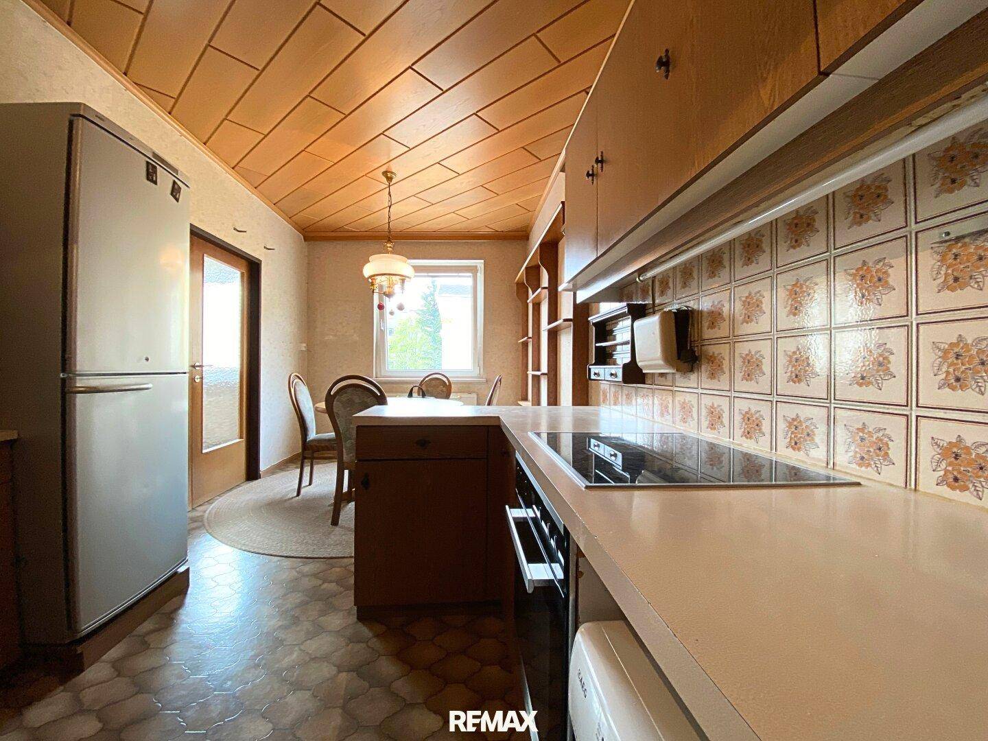 Traditionelle Küche mit Holzdecken, Einbauschränken und einem Essbereich, der zum Verweilen einlädt.