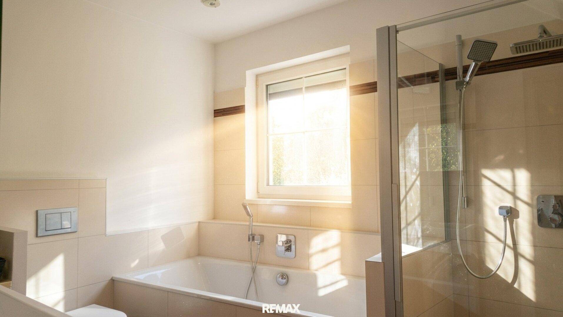 Modernes Badezimmer mit Badewanne, Duschkabine und einem Fenster für Tageslicht.