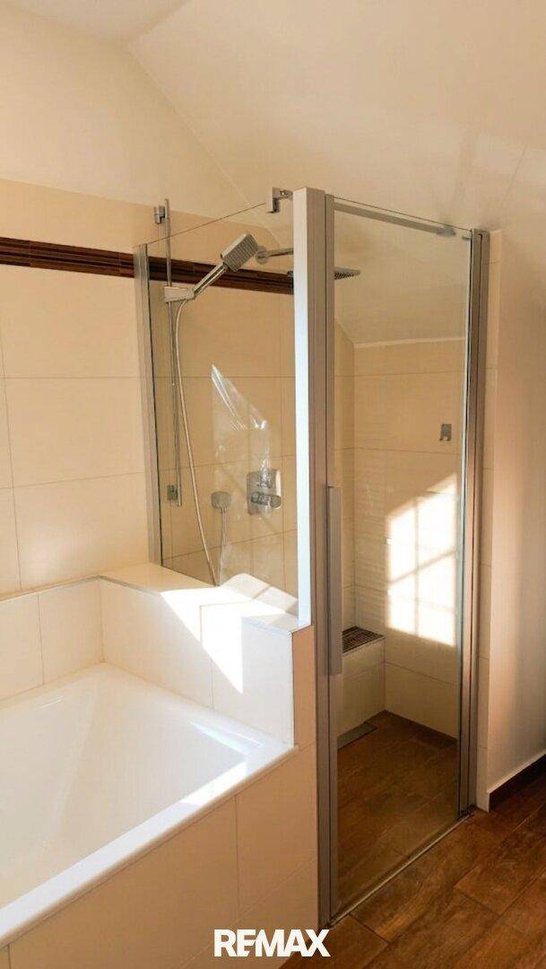 Funktionales Badezimmer mit einer geräumigen Duschkabine und einer Badewanne.