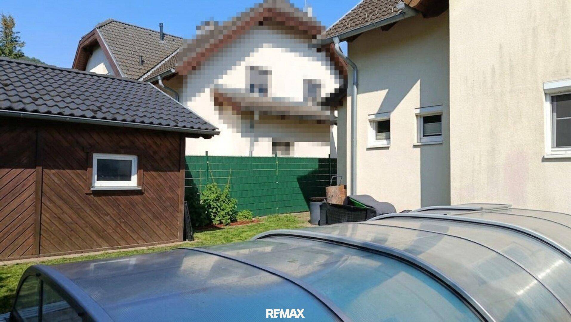 Ansicht des Hauses und eines Schuppens mit einem abgedeckten Swimmingpool im Vordergrund.