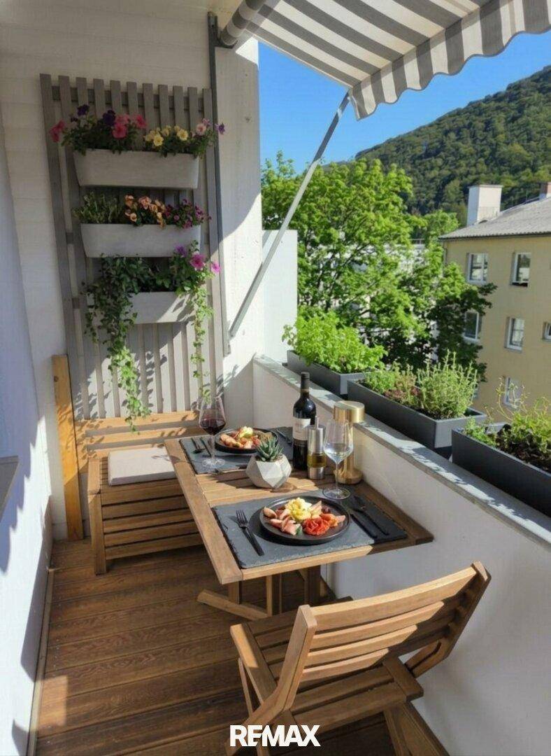 Einladender Balkon mit Holzboden, Esstisch und Blick auf die umliegende Natur.